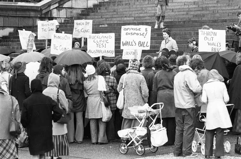 Photo: Alexander Turnbull Library. Dame Cath on the steps of Parliament, 20 September 1974, at a rally against the Wall Bill aimed at closing the AMAC clinic in Auckland. 